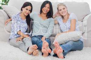Friends sitting on floor smiling at camera