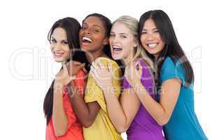 Diverse young women laughing at camera and embracing