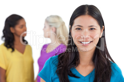 Smiling asian woman looking at camera with two women behind her