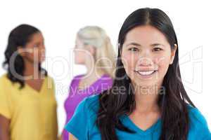 Smiling asian woman looking at camera with two women behind her