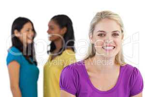 Smiling blonde woman looking at camera with two women behind her