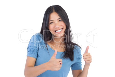 Smiling asian woman giving thumbs up at camera