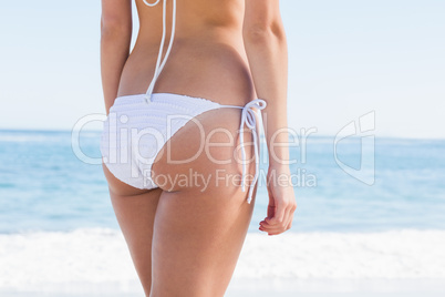 Rear mid section of fit woman in white bikini