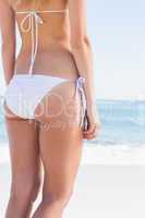 Rear mid section of toned woman in white bikini