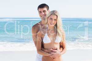 Attractive couple embracing and smiling at camera