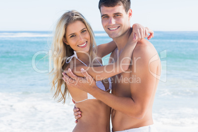Gorgeous couple hugging and smiling at camera