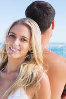Pretty blonde smiling and leaning against her boyfriend