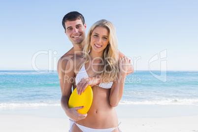 Man holding frisbee and hugging his girlfriend