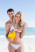 Man holding frisbee and embracing his girlfriend