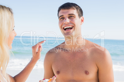 Woman putting sun cream on boyfriends nose