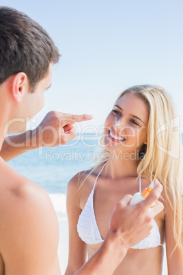 Man putting sun cream on cute girlfriends nose