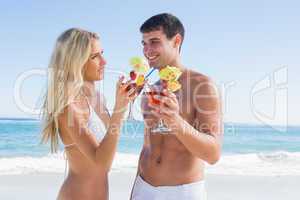 Happy young couple holding cocktails