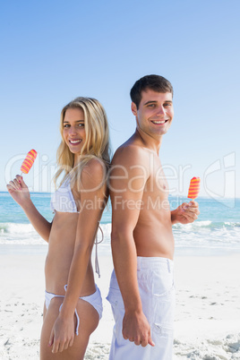 Happy young couple holding ice creams smiling at camera
