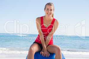 Fit young woman sitting on exercise ball looking at camera