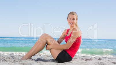 Athletic blonde sitting and smiling at camera