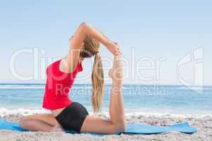 Fit blonde stretching leg in yoga pose