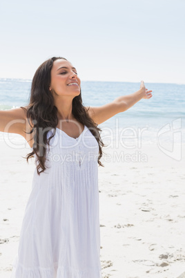 Content brunette in white sun dress enjoying the sun