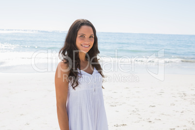 Content brunette in white sun dress looking at camera