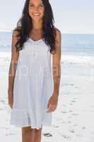 Happy brunette in white sun dress walking towards camera