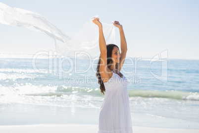 Happy brunette in white sun dress holding sarong