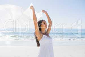 Pretty brunette in white sun dress holding sarong