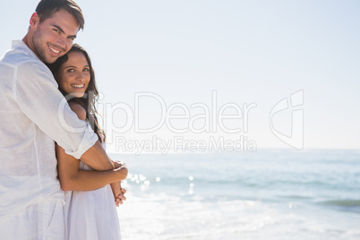 Smiling couple hugging and looking at camera