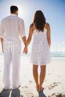 Attractive couple holding hands and watching the water