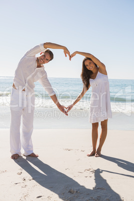 Romantic couple forming heart shape with arms