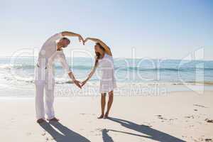 Cute couple forming heart shape with arms