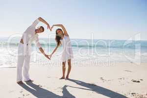 Loving couple forming heart shape with arms