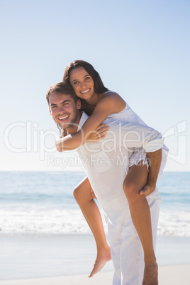 Smiling man giving happy girlfriend a piggy back