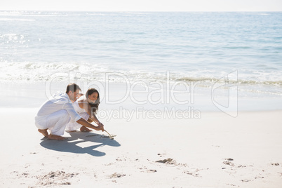 Cute couple drawing in the sand