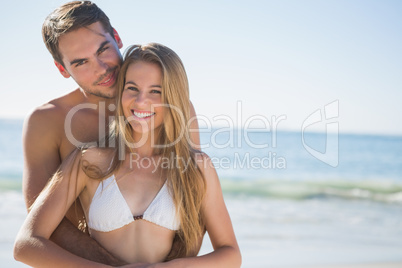Athletic couple smiling at camera and embracing