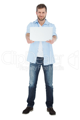 Cheerful man showing laptop to camera and smiling