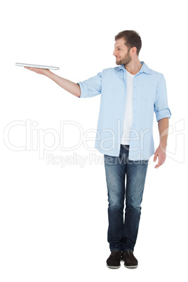Cheerful model holding laptop on right hand