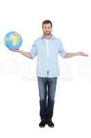 Charming young model holding a globe and looking at camera