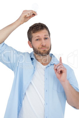 Cheerful model holding light bulb above his head