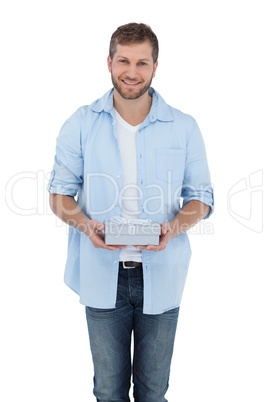 Attractive man holding a gift looking at camera
