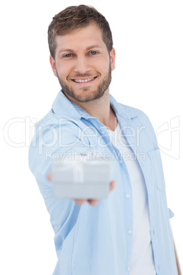 Portrait of smiling young model offering gift