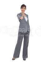 Young businesswoman looking at camera giving thumb up