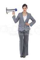 Serious businesswoman holding loudspeaker