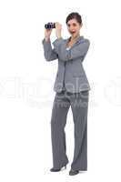 Astonished businesswoman posing with binoculars