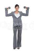 Businesswoman posing with dumbbells