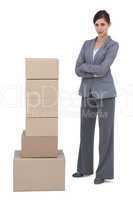 Confident businesswoman with cardboard boxes