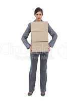 Serious businesswoman carrying cardboard boxes
