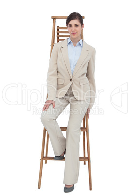 Young businesswoman sitting on career ladder