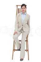 Young businesswoman sitting on career ladder