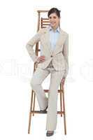 Smiling businesswoman sitting on career ladder