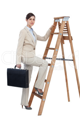 Businesswoman climbing career ladder with briefcase and looking