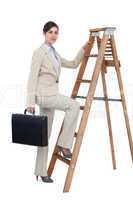 Businesswoman climbing career ladder with briefcase and looking